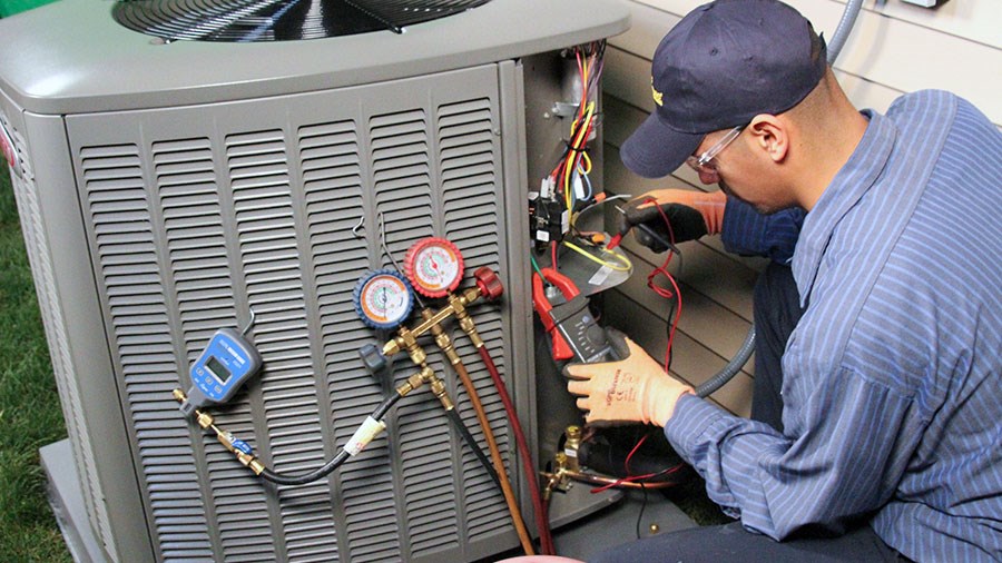 A/C Technician working on a/c unit outside