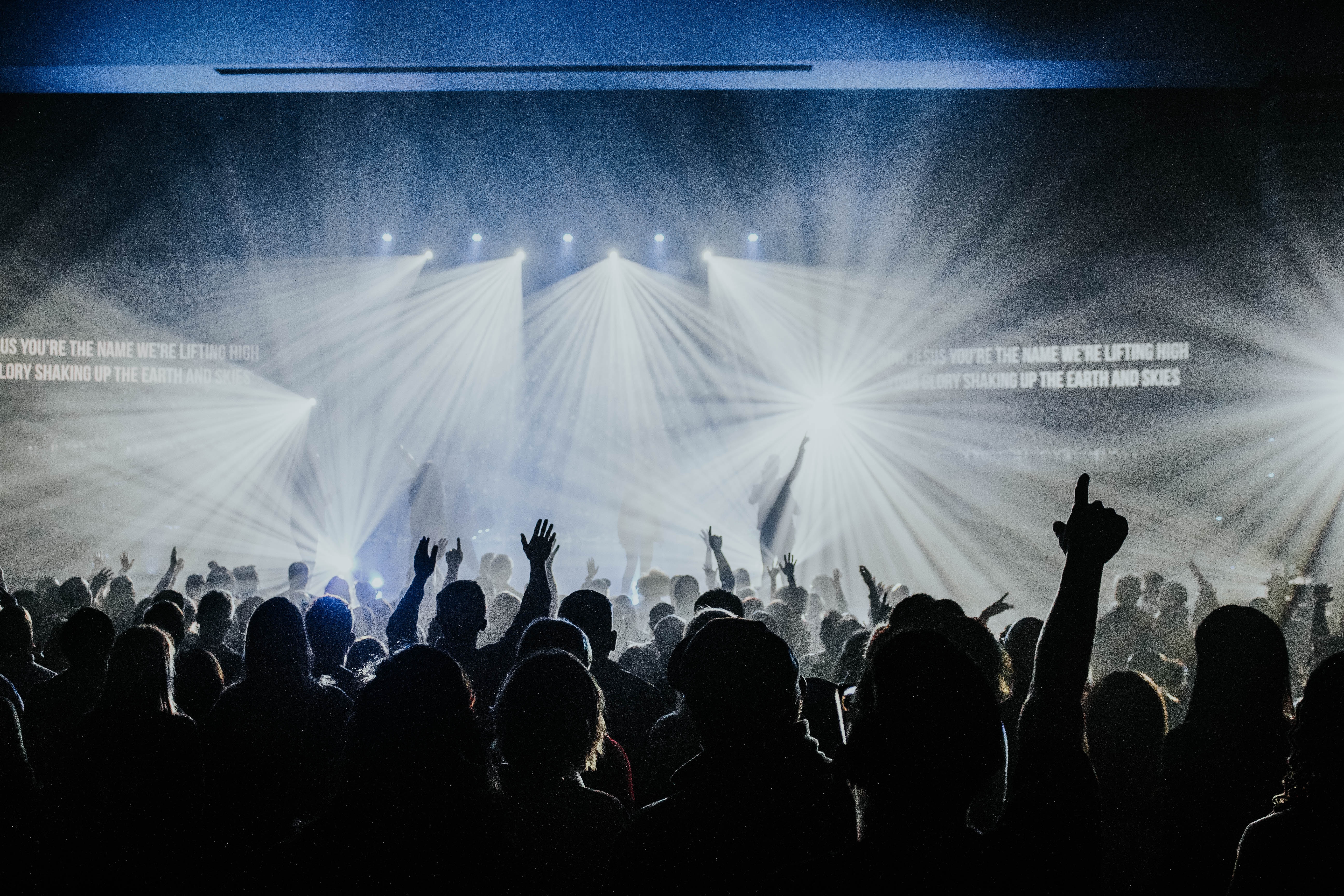 people at a concert with hands raised